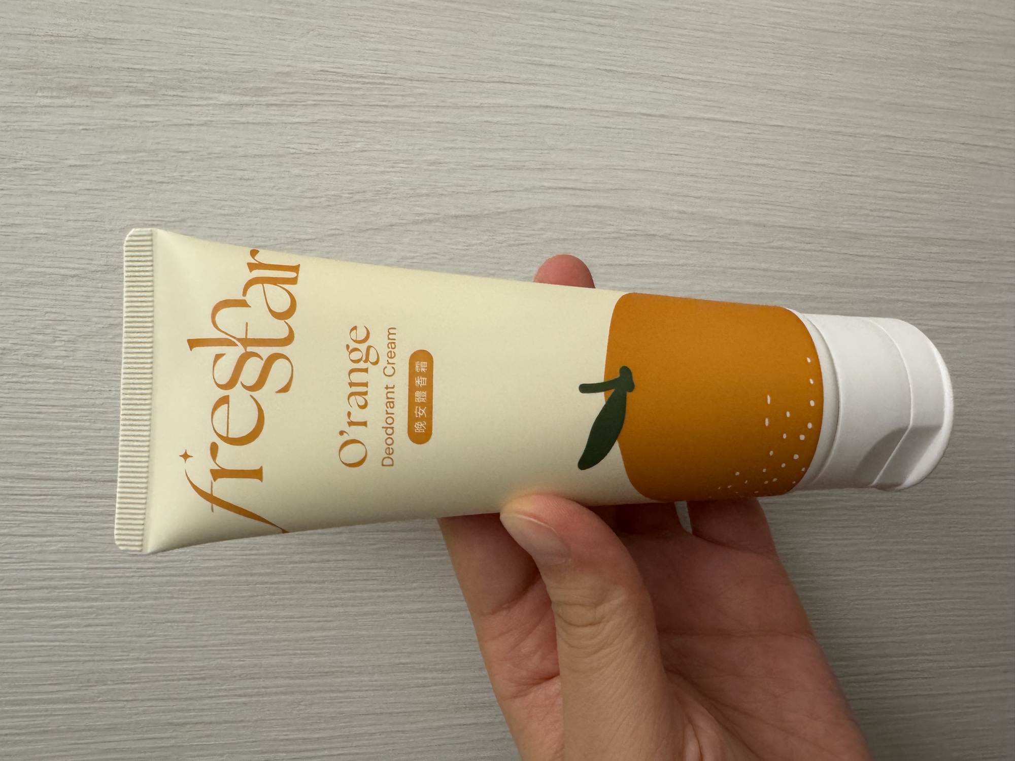 管身正面手持。fresh star／O'range／Deodorant Cream／晚安體香霜，下半部是柑橘插畫。
