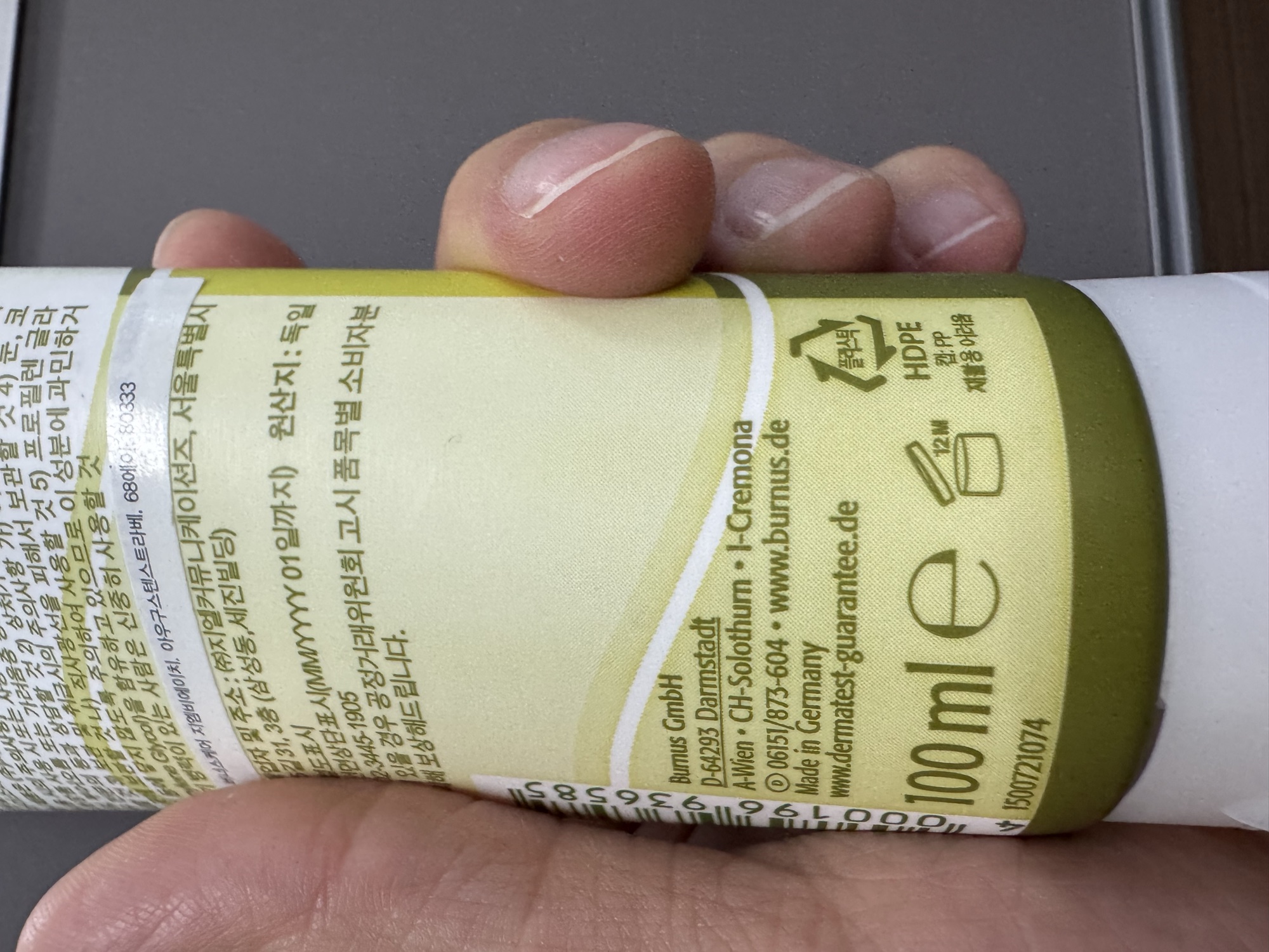 管身下段。Burnus GmbH 德國原廠資訊、100 ml e、開蓋圖示 12M、HDPE 回收標、原산지 독일。