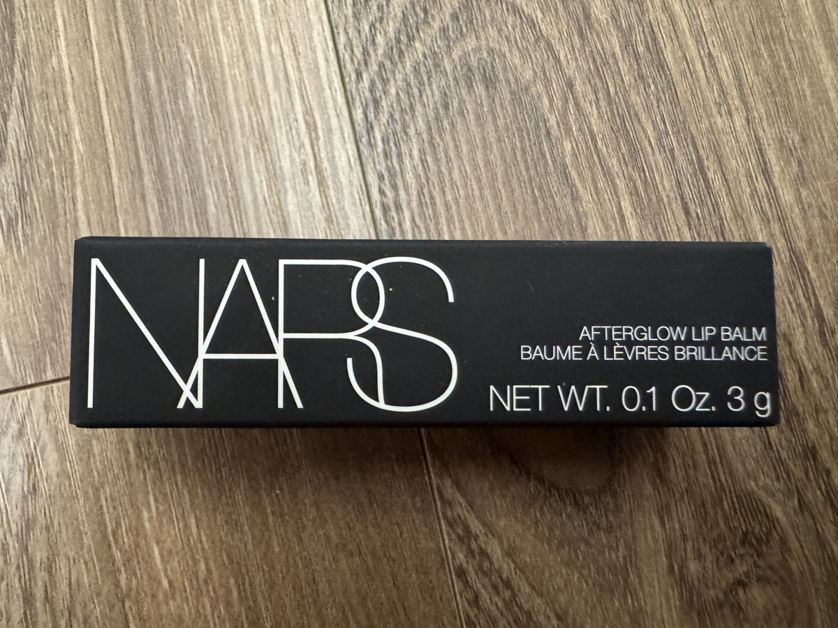 外盒正面。NARS AFTERGLOW LIP BALM／BAUME À LÈVRES BRILLANCE，NET WT. 0.1 Oz. 3 g。