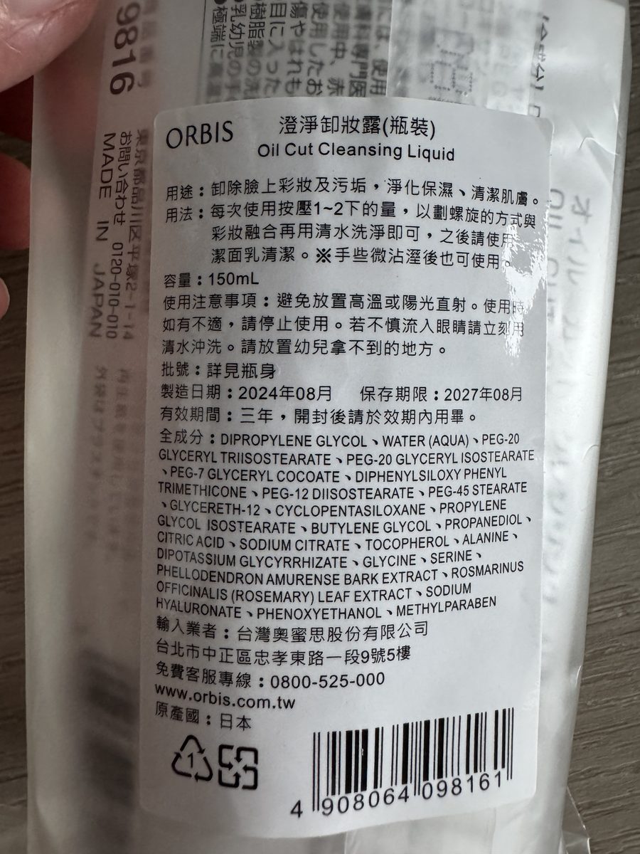 中文標示貼紙特寫。品名「澄淨卸妝露(瓶裝) Oil Cut Cleansing Liquid」、用途、用法、容量 150mL、使用注意事項、批號詳見瓶身、製造日期 2024年08月／保存期限 2027年08月、有效期間三年，以及【全成分】25 項（DIPROPYLENE GLYCOL 起、METHYLPARABEN 止）與輸入業者 台灣奧蜜思股份有限公司、原產國 日本、條碼 4908064098161。