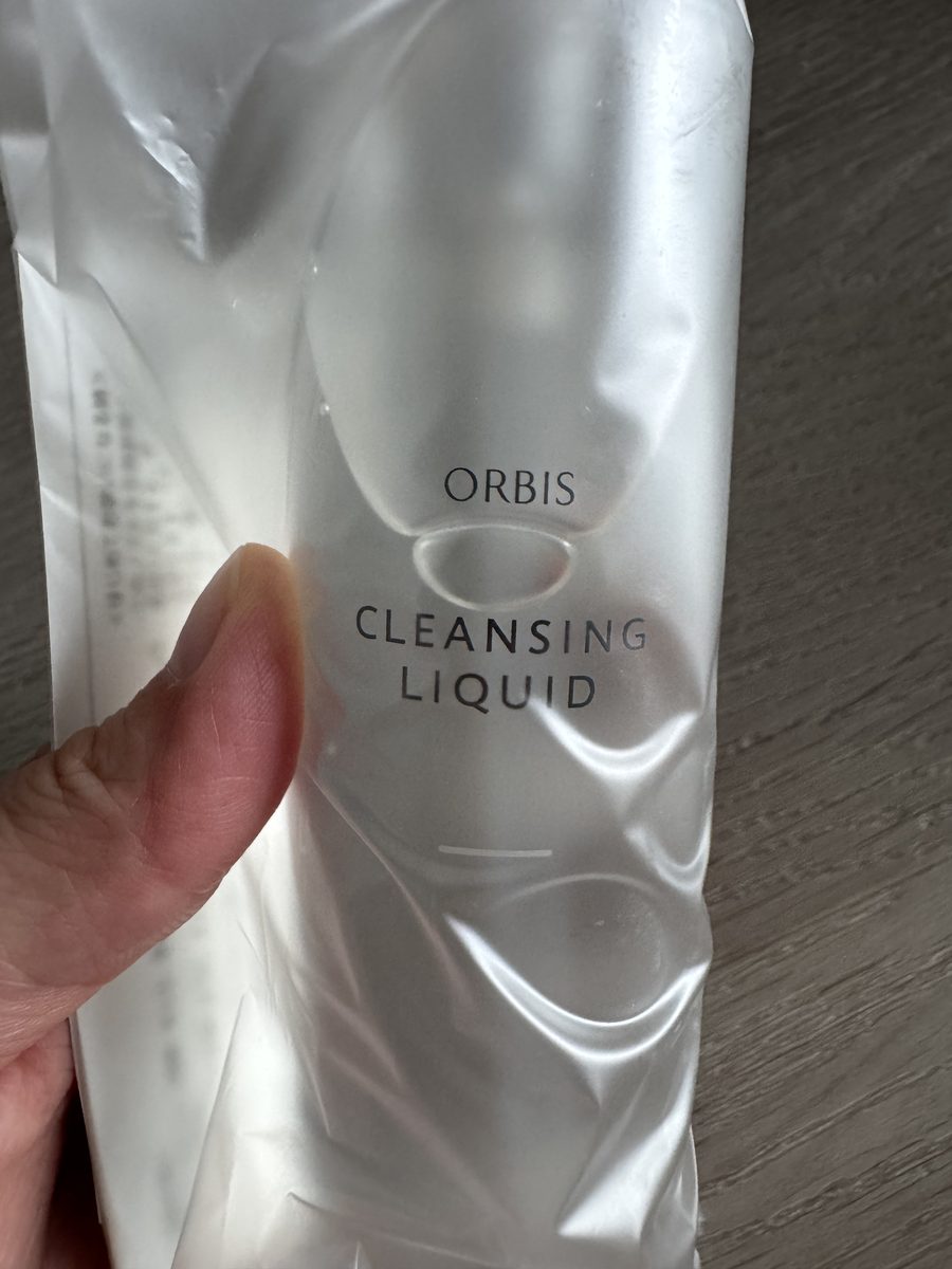 瓶身正面壓紋特寫。ORBIS 與 CLEANSING LIQUID 為印刷字，中間為瓶身本體的橢圓壓紋。