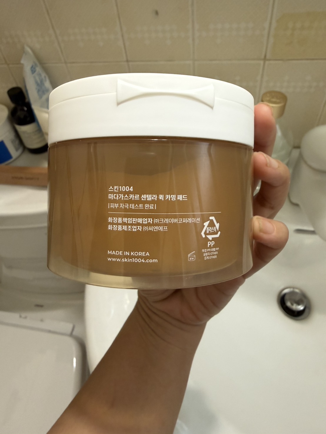 罐身背面韓文標示。스킨1004／마다가스카르 센텔라 퀵 카밍 패드／화장품책임판매업자 ㈜크레이버코퍼레이션／MADE IN KOREA／開蓋圖示 6M。