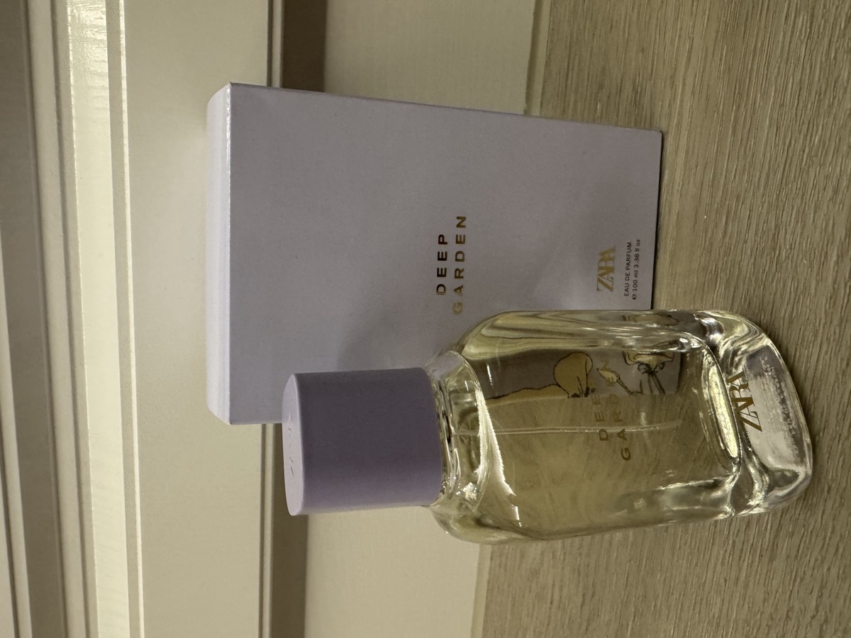 瓶身與外盒正面。淺紫瓶蓋，玻璃瓶身印 DEEP GARDEN 與 ZARA。